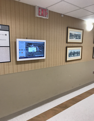 Wall-mounted healthcare kiosk in a facility corridor